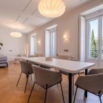 Comedor amplio con mesa para seis y balcón con vistas a los árboles de la plaza — fotografía inmobiliaria Chueca Madrid