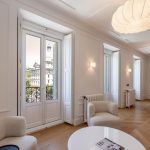 Salón comedor con balcón francés y vistas a edificio clásico, sillones boucle — reportaje de fotógrafo inmobiliario en Chueca